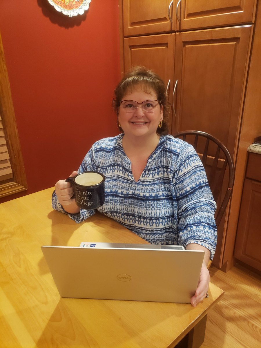 Lisa Doyon at her kitchen table, holding a mug, with a laptop in front of her